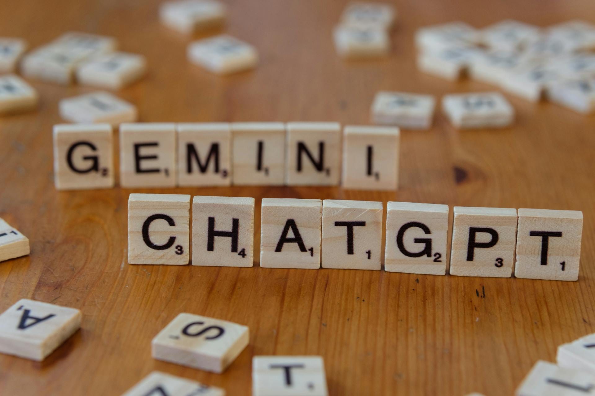 Holzbuchstaben auf einem Tisch bilden die Begriffe „Gemini“ und „ChatGPT“ – zwei führende KI-Systeme im kreativen und strategischen Einsatz